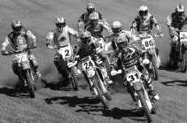 Joshua Coppins duikt als eerste de bocht in voor Kevin Strijbos en Stefan Everts.