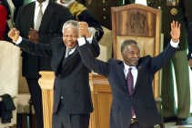 Volgens de aanklacht heeft de regeringspartij ANC van Nelson Mandela (l.) en Thabo Mbeki bij de machtsovername in 1994 de verantwoordelijkheid geërfd van het blanke apartheidsregime.