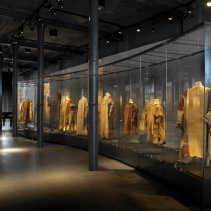 De kleren zijn op paspoppen gehangen, wat ongebruikelijk is voor oud textiel. Om de tere weefsels optimaal voor aftakeling te behoeden, zouden ze eigenlijk horizontaal bewaard moeten worden.