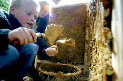 Met leem en wilgenteen leren kinderen een Limburgse hoeve in het klein na te bouwen in het Openluchtmuseum.