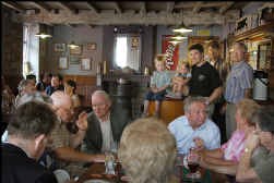 De familie Panneels midden in haar tjokvolle café. Op de toog zitten de kinderen Jan en Ina, achter hen staan broers Yves en Kurt en vader Maurice.