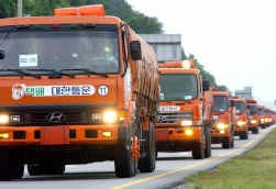 Zuid-Koreaanse vrachtwagens brengen rijst naar het verpauperde Noord-Korea.