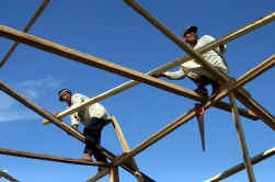 Atjeh-bouwvakkers werken aan de dakconstructie van een nieuwe huizenrij.