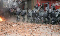 De Nepalese politie, in vol gevechtsornaat, chargeert. Maar de hardnekkigheid van het straatprotest neemt met de dag toe.