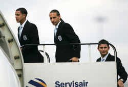 Theo Walcott (links) stapte samen met Rio Ferdinand (midden) en Frank Lampard op het vliegtuig richting Duitsland.