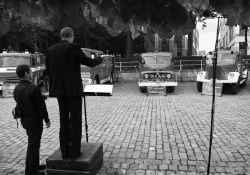 Acht oldtimerbrandweerwagens spelen een compositie van het Spectra Ensemble.