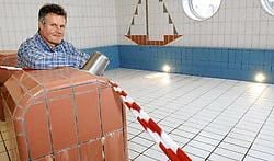 Sportfunctionaris Paul Deruyck in het drooggelegde peuterzwembad. Tot 5 maart wordt hier niet gezwommen om uit te zoeken of het bad, dat zich pal boven zijn bureau bevindt, de oorzaak is van de waterinsijpeling.<br>David Stockman