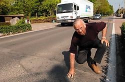 Buurtbewoner Jozef Martelé toont de verzakkingen in de Aartrijkestraat die lawaaioverlast en trillingen veroorzaken. Michel Vanneuville