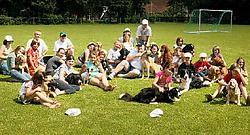Louis Schoofs zit in het midden van de groep met kinderen en hondjes. De kinderen volgen bij hem les hoe ze met honden moeten omgaan. Inge Van den Heuvel<br>
