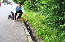 Buurman Herman Christiaan toont de kloof tussen het asfalt en de oever van de Trekweg.kl