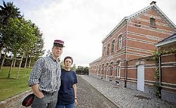 Jo Uytterhoeven en Hilde Pottel voor hun station in rode, gele en zwarte steen. Het is het eindpunt van het fietspad.<br>Jef Collaer<br>