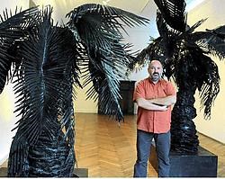 Hans Martens tussen de verwrongen palmbomen van kunstenaar Peter Rogiers. Gianni Barbieux