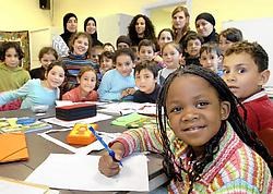 Een twintigtal allochtone kinderen maken samen met zeven begeleiders huiswerk in de lokalen van het Oost-Vlaams Diversiteitscentrum.<br>David Stockman