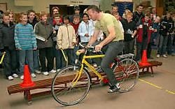 Johan Museeuw kroop op de fiets om de leerlingen te tonen waar gevaren schuilen. Peter Maenhoudt