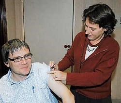 Huisarts Griet Vandemoortele spuit burgemeester Patrick Lansens in met het griepvaccin. Isabelle Vanhassel<br>