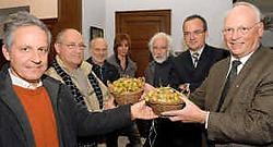 Een delegatie van het SAK Sint-Pieters heeft Bernard De Cuyper een mandje overhandigd met vruchten van de Japanse notenboom. <br> Michel Vanneuville<br>