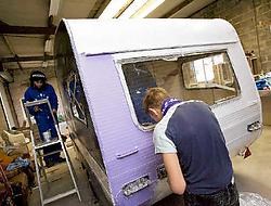 De jongeren leren samenwerken door aan een caravan te 'prutsen'.Jef Collaer <br>