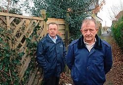 Roger Appelmans (rechts) staat met buurman Bob Reymaekers (achter Roger) bij het poortje waar de hond werd toegetakeld. Yvan De Saedeleer