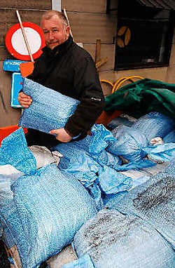 Jacky Coopman toont de nieuwe zandzakjes in synthetisch materiaal. Ze hebben een levensduur van tien jaar. Isabelle Vanhassel