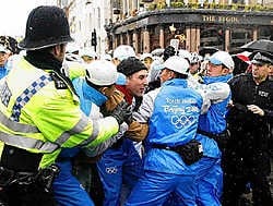 De Chinese veiligheidsagenten houden een betoger in Londen tegen. De oud-atleet Sebastian Coe, die langs het parcours stond, noemt ze 'schurken'. 'Drie keer hebben ze geprobeerd om me weg te duwen. Ze zijn verschrikkelijk.'ap<br>