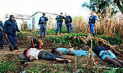 Politieagenten bij de lichamen van enkele slachtoffers in Johannesburg. Meer dan vijftienduizend mensen zijn op de vlucht geslagen.afp<br>