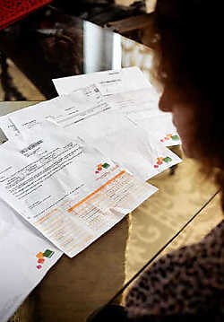 Arena A. buigt zich over de facturen en herinneringsbrieven die haar ongewild abonnement haar opleverden.Emy Elleboog<br>