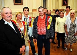 Op de voorgrond voorzitter Henri Van Hoecke van Schuttersmaatschappij Willem Tell, secretaris Cindy Van Hoecke, het jonge lid Nico Schmit en penningmeester Marc Van Hoecke. Op de achtergrond staan enkele leden tijdens de ontvangst in het stadhuis. Koen Me