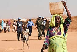 Een vrouw wandelt langs een controlepost van de Verenigde Naties, bij het vluchtelingenkamp Abu Shouk (Noord-Darfour). De VN-vredesmissie is verlengd, maar haar opdracht blijft ambigu en dus bedreigd.ap<br>