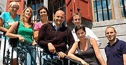 Geena Lisa en Steph Goossens, samen met de vijf sleutelfiguren die de opdrachten tot een goed einde moeten brengen.