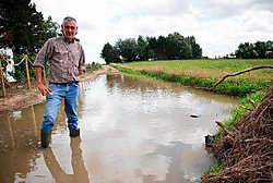 Paul Vanherrewegen in de grote plas die de toegang tot de Quirinusweg onmogelijk maakt. Jef Collaer