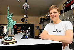 Rita Van Ryckeghem houdt Café New York open: 'Vooral vanaf de jaren 1880 zijn veel Doomkerkenaren uitgeweken, twee op de drie inwoners vertrokken toen met de Red Starline en hun ticket kochten ze hier.'<br>