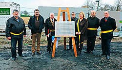 De burgemeester en schepenen hebben het bord dat aan de uitgebreide sporthal komt onthuld. Stefaan Beel