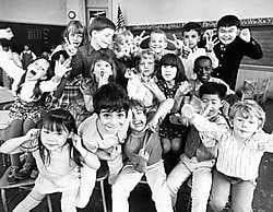 Kinderen trekken gekke bekken voor de schoolfotograaf. corbis<br>