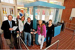 Stadsarchitect Jean-Pierre Vanacker, sportdirecteur Mia Maes, sportschepen Stefaan Bral, facility-schepen Hilde Demedts en Sara Ferlin (facility) in het geautomatiseerde toegangsgebouw van het zwembad Abdijkaai. phk
