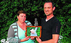 Moeder Claire en vader Ronny in de tuin met de foto van hun overleden zoon Bram. <br>Marc Vergote