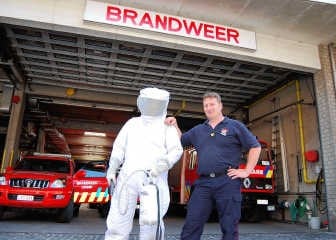 Wouter Moonens, brandweerman van het korps van Lennik met naast hem een collega in een beschermend pak voor de brandweerlieden. Jelle Schepers