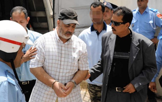 Abdelkader Belliraj wordt naar de rechtszaal in Rabat geleid.afp