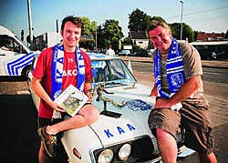 Jan Desmarets overhandigde winnaar John zijn prijs, een beeldhouwwerk van een voetballer. SvdE
