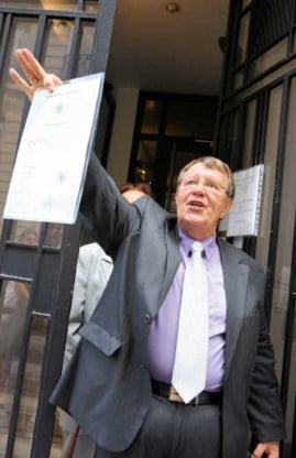 Daniel Rouxel zwaait met het document dat hem de dubbele, Frans-Duitse, nationaliteit verleent.afp