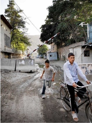 Jongeren passeren een checkpoint van de politie vlakbij de Indiase ambassade in Kabul.Wouter Van Vooren
