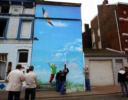 Een reuzenfoto van een spelend kind verbergt het gruwelhuis. belga