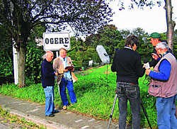 Luc Vandeplas (links) bij medewerkers van zijn revue aan een bord in Hoegaarden: 'Ogere'.Raymond Billen