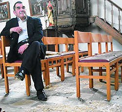 Pastoor Marcel Struyf bij de brokstukken in de Sint-Joriskerk in Oorbeek. Inge Bosschaerts