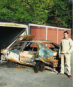 Saïd Boudaou bij zijn uitgebrande auto.ksg