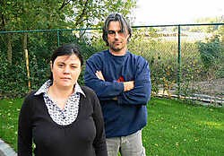 Erika D'Hauwe en Patrick De Stercke in de tuin. Pal achter de omheining zou de parking van de club komen. jrz