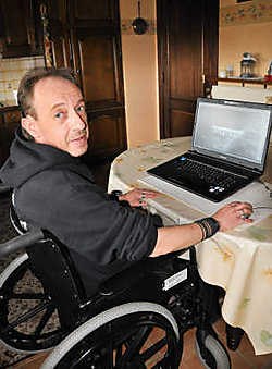 Marc Van Aerschot voor zijn pc die de metalen implantaten in zijn schouder weergeeft.Fernand Goyens