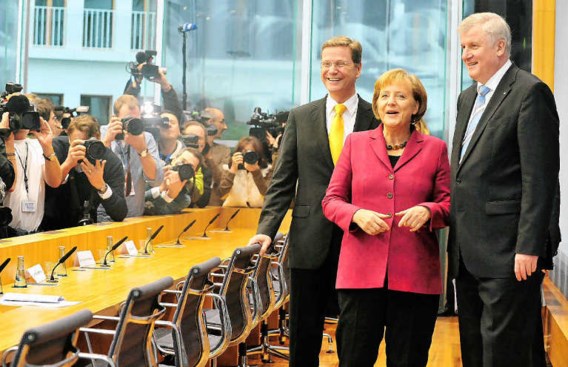 Angela Merkel presenteert haar nieuwe regering, omringd door Guido Westerwelle (links) en Horst Seehofer (rechts). epa
