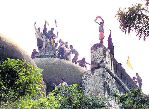 Fanatieke hindoes op het dak van de Babri Masjid moskee, enkele uren voor ze vernield zou worden.afp