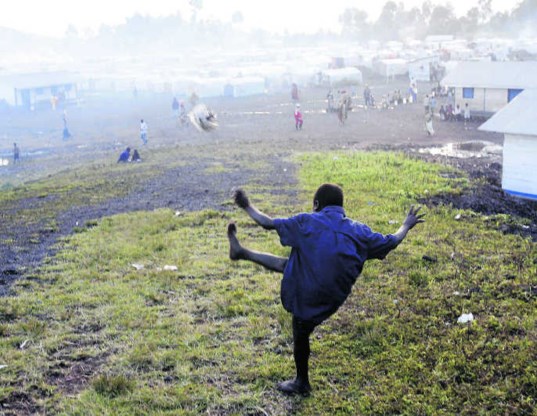 Een vluchteling trapt een balletje in het Kibati-kamp in Oost-Congo. epa