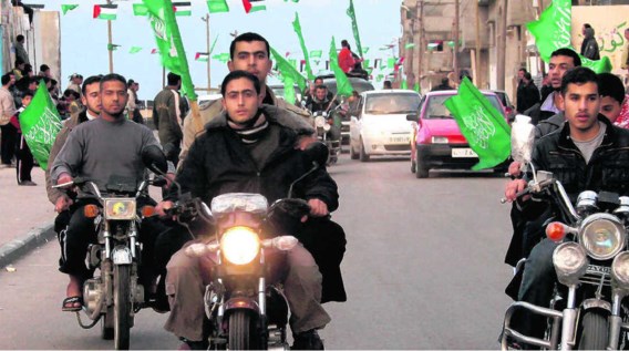 Palestijnen toeren met de groene Hamas-vlag door Gaza-Stad. Voor vrouwen is een verbod op motorrijden ingevoerd. Ze mogen wel nog autorijden.epa